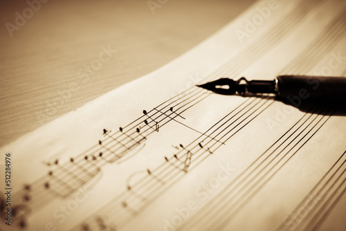 Music sheet, sheet music and feather, concept of composing music, music background photo