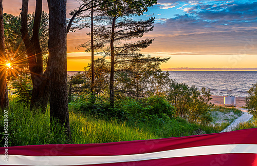 Colorful sunrise at sandy beach of the Baltic Sea in Jurmala - famous tourist...