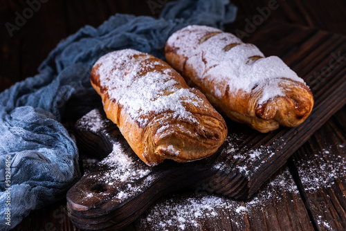 A cup of black tea and a plate with homemade bakery, biscuit on a wooden table. Close-up.