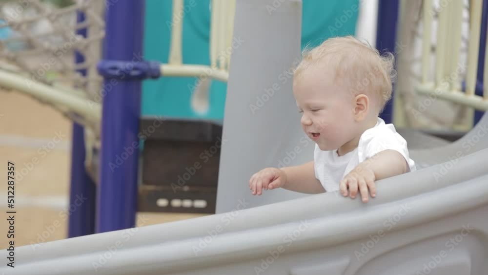 Child Coming down Playground Slide. Happy Children Playing on Playground Child Coming down Playground Slide. Happy Children Playing on Playground