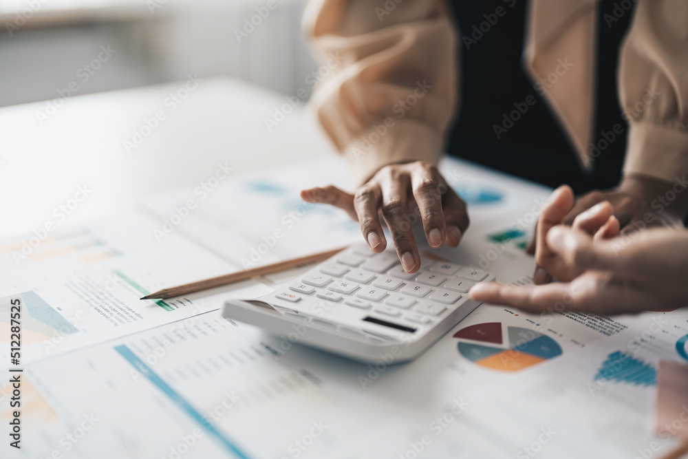 Fototapeta premium Close up Businessman and partner using calculator and laptop for calaulating finance, tax, accounting, statistics and analytic research concept