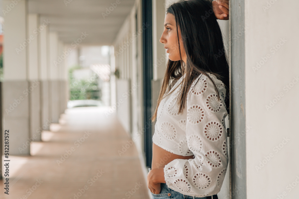 portrait of latin american woman standing leaning against wall portrait of latin american woman standing leaning against wall