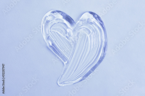 Cosmetic gel in shape of heart on the blue background.Copy space for text,mockup concept.