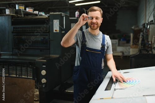 Funny portrait of typographer standing with color swatches at the printing manufacturing photo