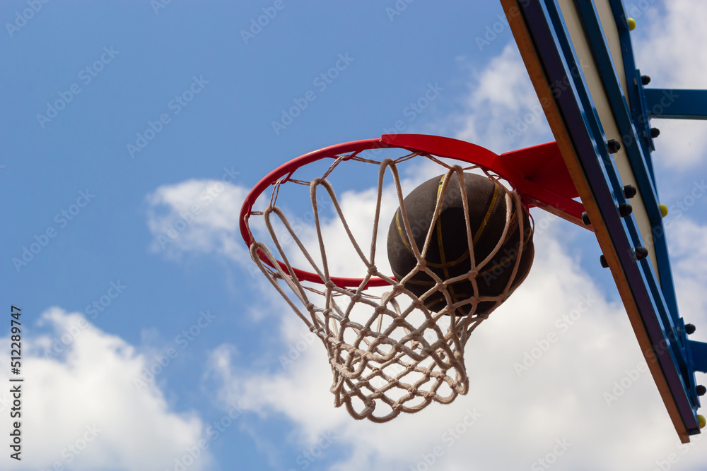 A basketball in the net. The fly ball is in the ring. A sports game. Conceptual: victory, success, hitting the target, sport. Successful ball throw