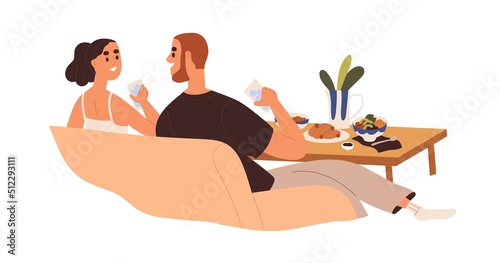 Love couple relaxing on sofa, eating food, talking. Happy man and woman on ro...