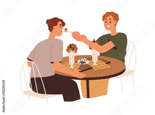 Love couple eating in cafe. Young man feeding woman with dessert from spoon o...