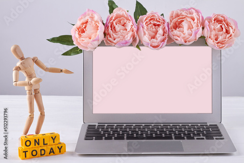Laptop decorated with peony flowers and mannequin. Only today concept. Screen for copy space. photo