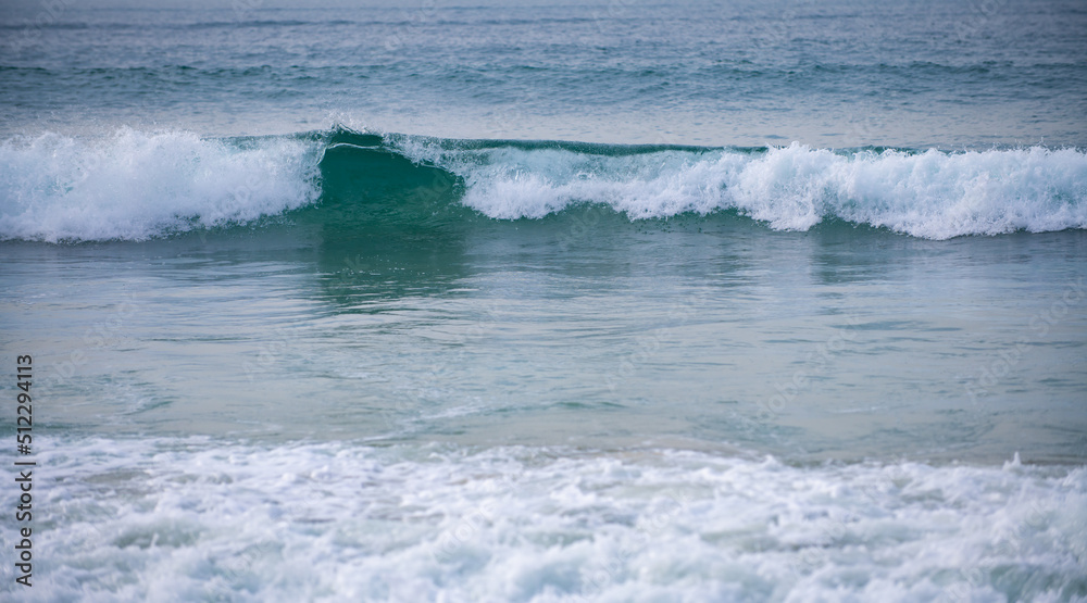 Summer beach, ocean waves on a tropical sea with deep blue wawes. Calm sea, ocean background.