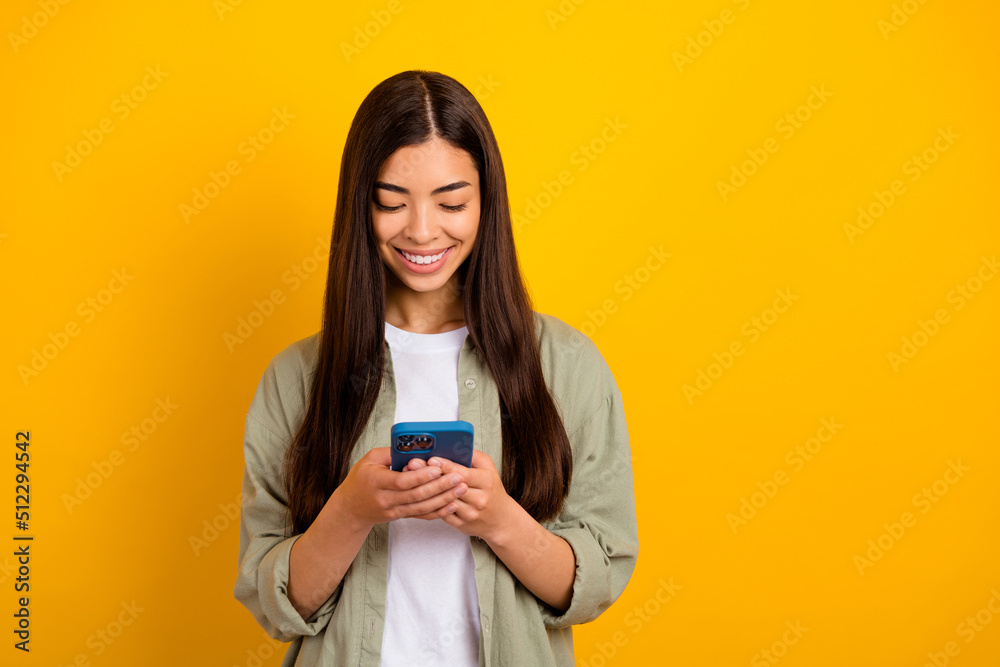 Photo of young pretty good mood girl blogger chatting with boyfriend in smartphone isolated on yellow color background Photo of young pretty good mood girl blogger chatting with boyfriend in smartphone isolated on yellow color background
