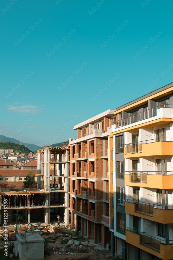 Urban landscape. Construction of a new house in the city on a background of mountains. Quality image for your project
