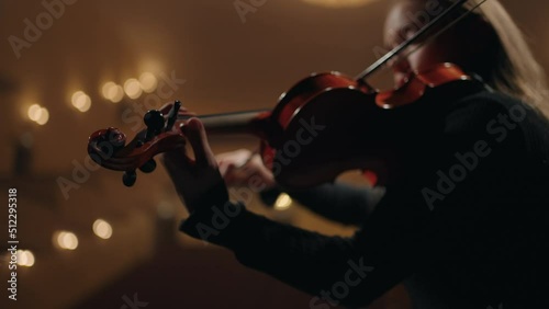 female violinist is playing violin in music school, closeup of fiddle in hands of woman