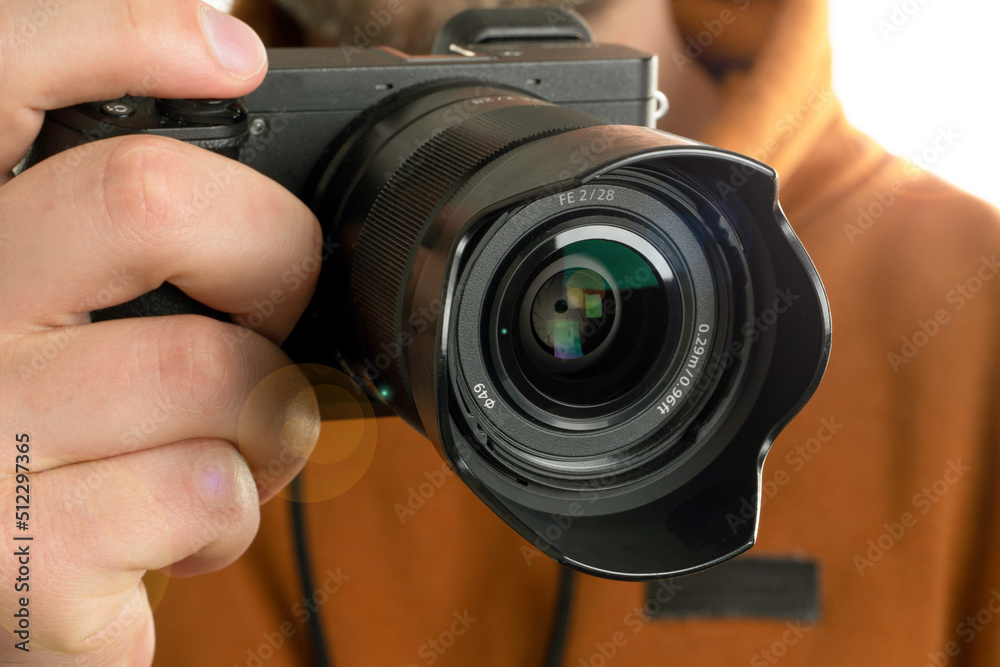 A close up image of man holding digital camera