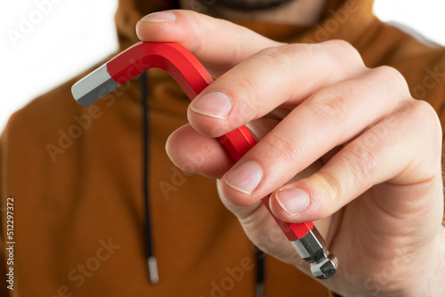 Close up image of man holding hex  screw tools 