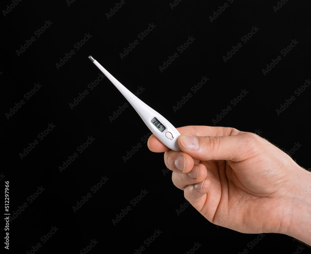 A close up image of man's hand holding a thermometer with high temperature. fever A close up image of man's hand holding a thermometer with high temperature. fever