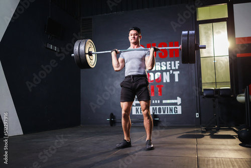 Muscular man workout in the gym doing exercises with barbell. workout exercises concept