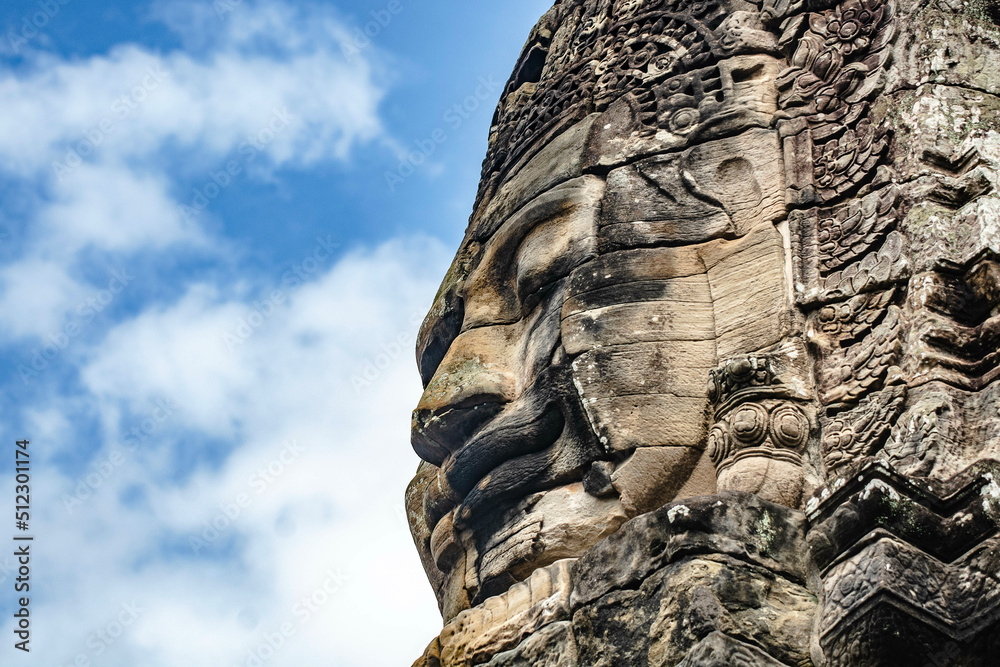 Fototapeta premium Sculpture of a smiling person's face on a large sandstone at Bayon Angkor Thom Temple, Siem Reap, Cambodia.