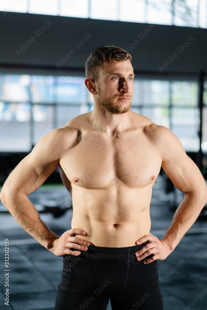 Obraz premium Athletic man posing hardcore in the gym