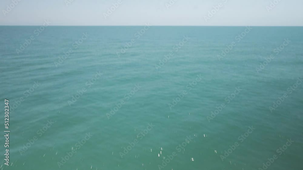 Dramatic aerial shot flying over breaking waves tilt reveal sea horizon Dramatic aerial shot flying over breaking waves tilt reveal sea horizon