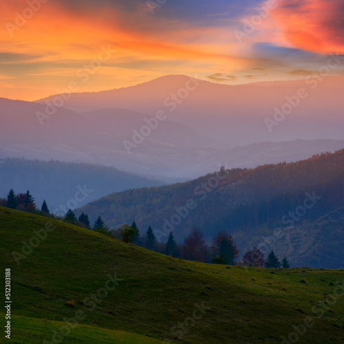 carpathian countryside at sunset. green grassy hills and meadows rolling in to the distant valley. borzhava mountain range beneath a sky with clouds in evening light