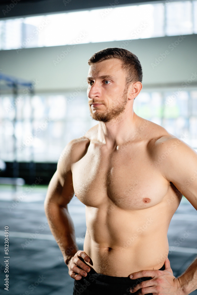Fototapeta premium Athletic man posing hardcore in the gym
