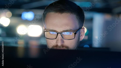 Close-up of a concentrated man in glasses who works at a computer.