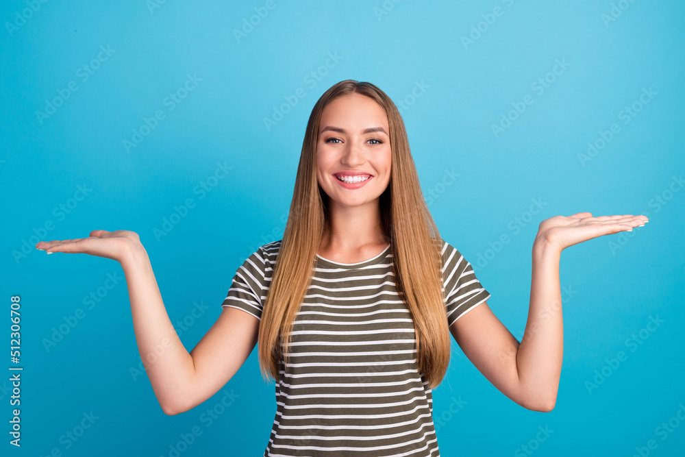 Photo of cheerful pretty girl arms palms demonstrate empty space proposition isolated on blue color background Photo of cheerful pretty girl arms palms demonstrate empty space proposition isolated on blue color background