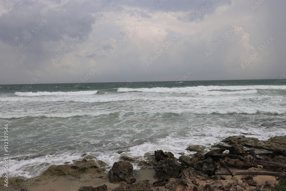 Beautiful sea waves impact rocky coast on the beach