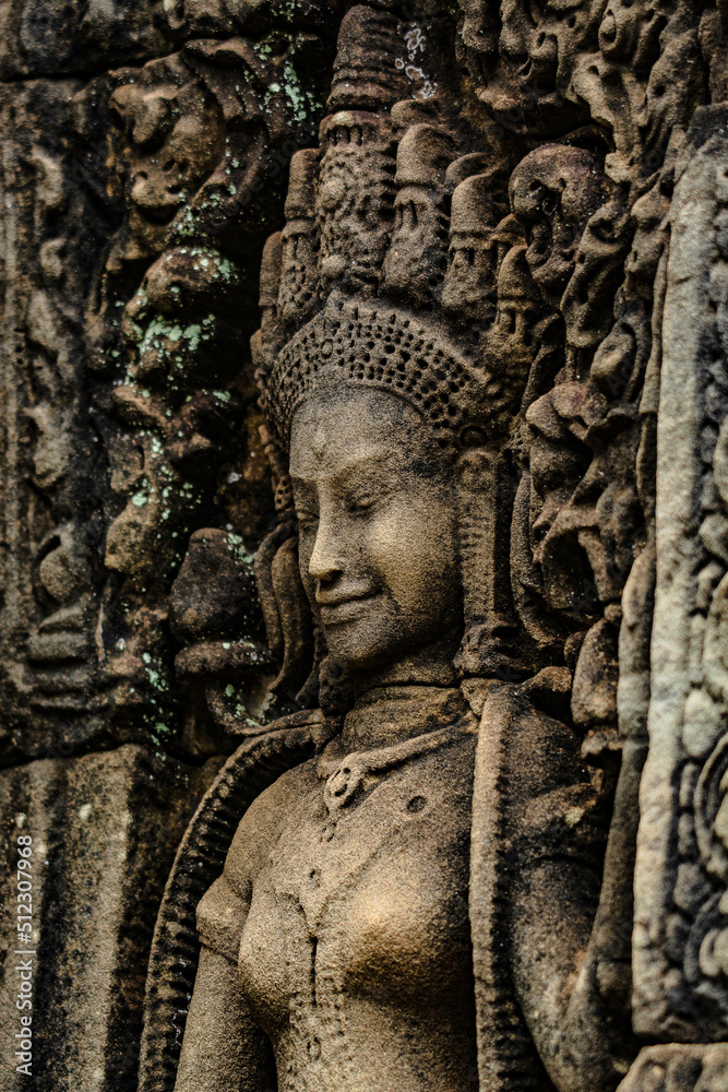 A sandstone sculpture of Apsara with a beautiful face and body at Bayon Angkor Thom Temple, Siem Reap, Cambodia.