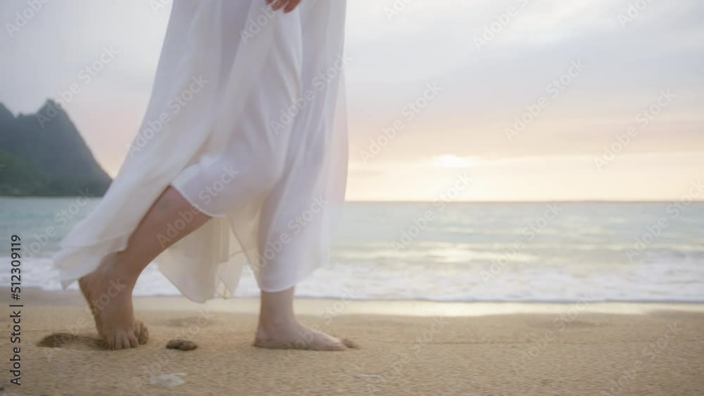 Slow motion woman in white boho dress walking barefoot by beach at ...