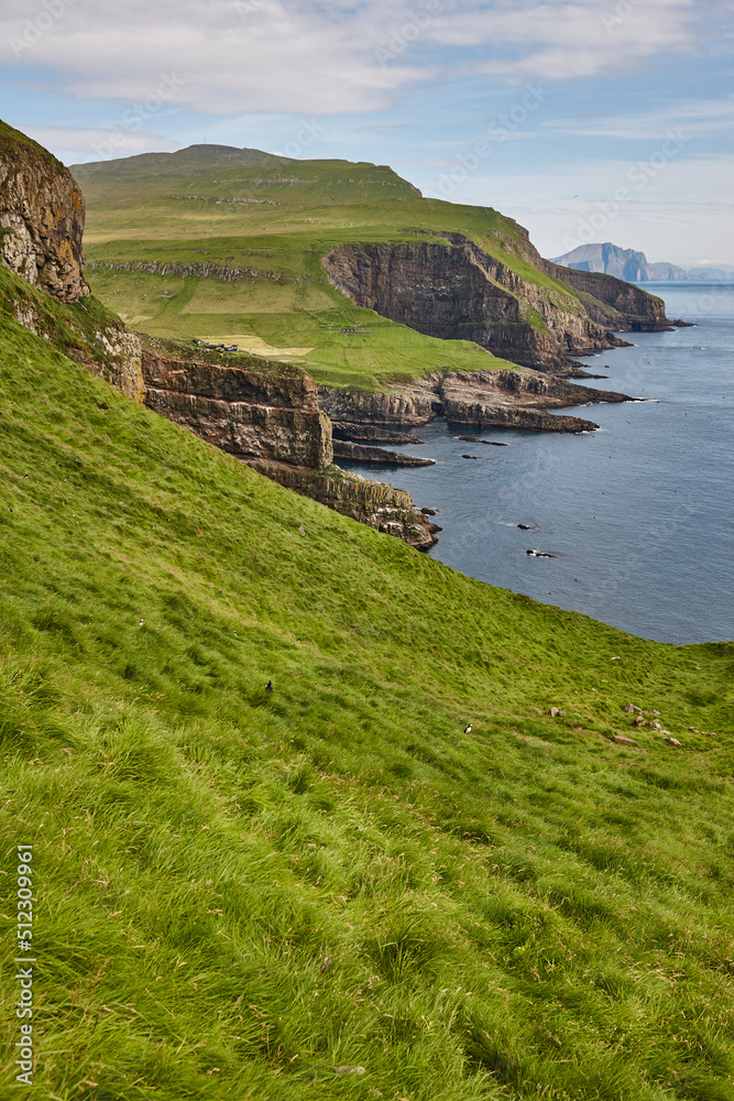 Mykines cliffs and lighthouse on Faroe islands. Hiking landmark