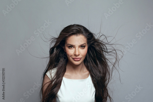Φωτογραφία Beautiful young dark-haired woman posing in the studio on a gray background