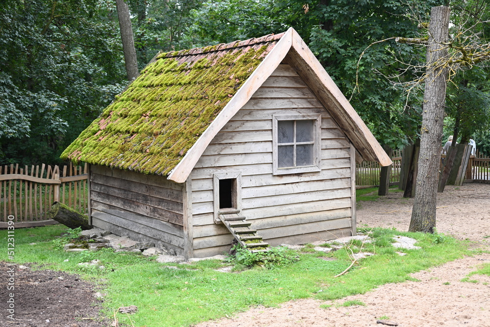 wooden chicken coop with moss on its roof