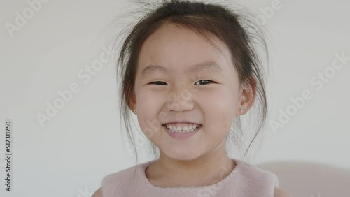 Portrait of a cute Asian baby girl looking straight into the camera, smiling and portraying happiness