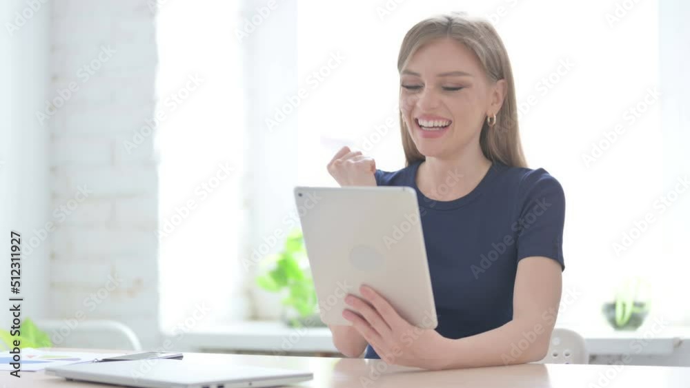 Woman Celebrating Success on Tablet in Office Woman Celebrating Success on Tablet in Office