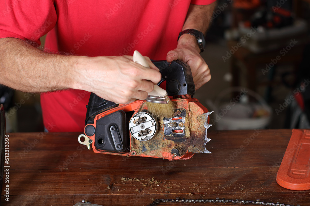 cleaning of the small chainsaw by a person cleaning of the small chainsaw by a person