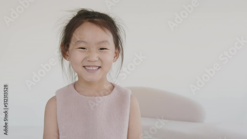 Portrait of a cute Asian baby girl looking straight into the camera, smiling and portraying happiness