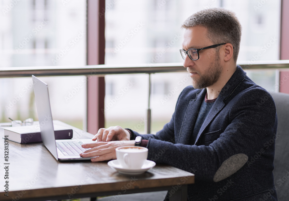 handsome man working on laptop for a cup of coffee in a restaurant