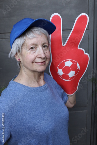 Sports fan holding large hand foam with enthusiam  photo