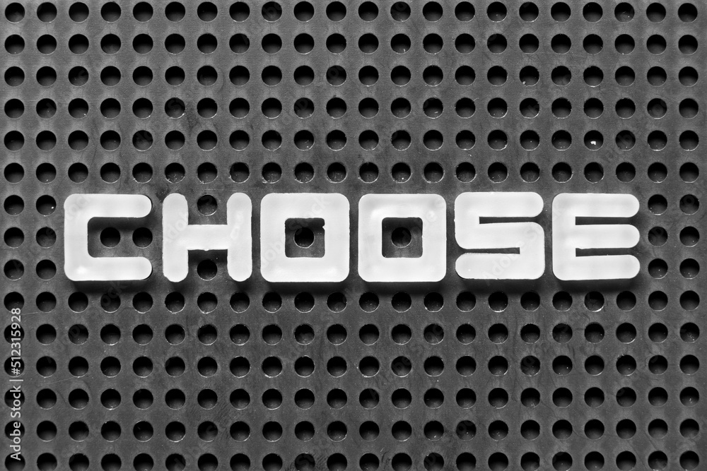 White alphabet letter in word choose on black pegboard background White alphabet letter in word choose on black pegboard background