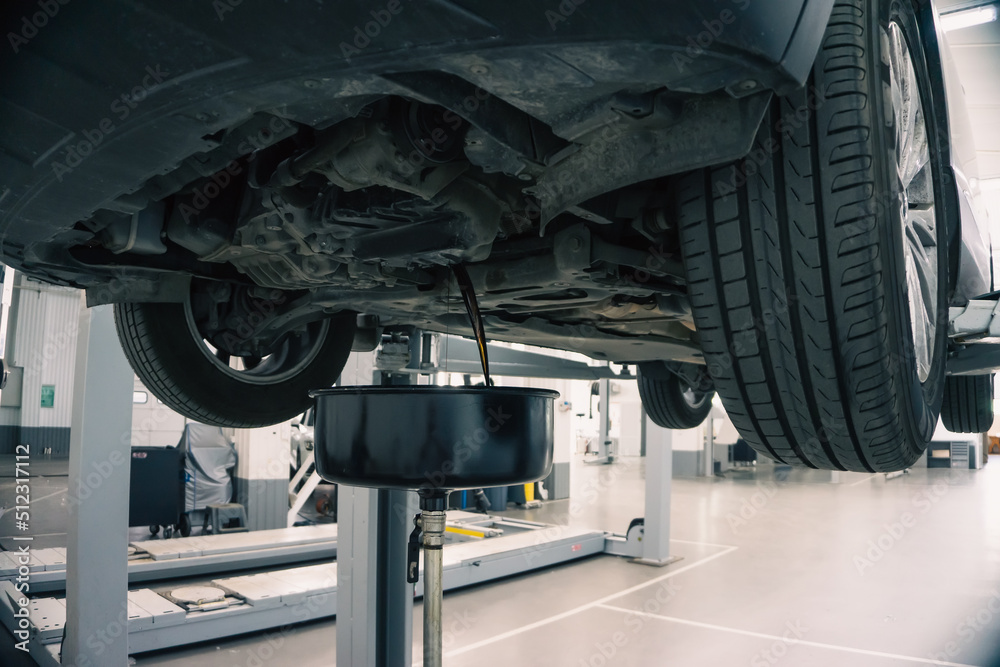 custom made wallpaper toronto digitalEngine oil change in car service. Auto is on hydraulic lift in garage workshop, process of draining old dark used oil.