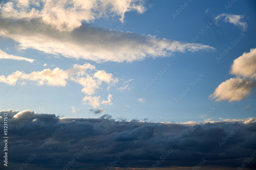 Naklejka premium Dark rain clouds in the evening sky. Dramatic sky with an coming cloudy cyclone of bad weather