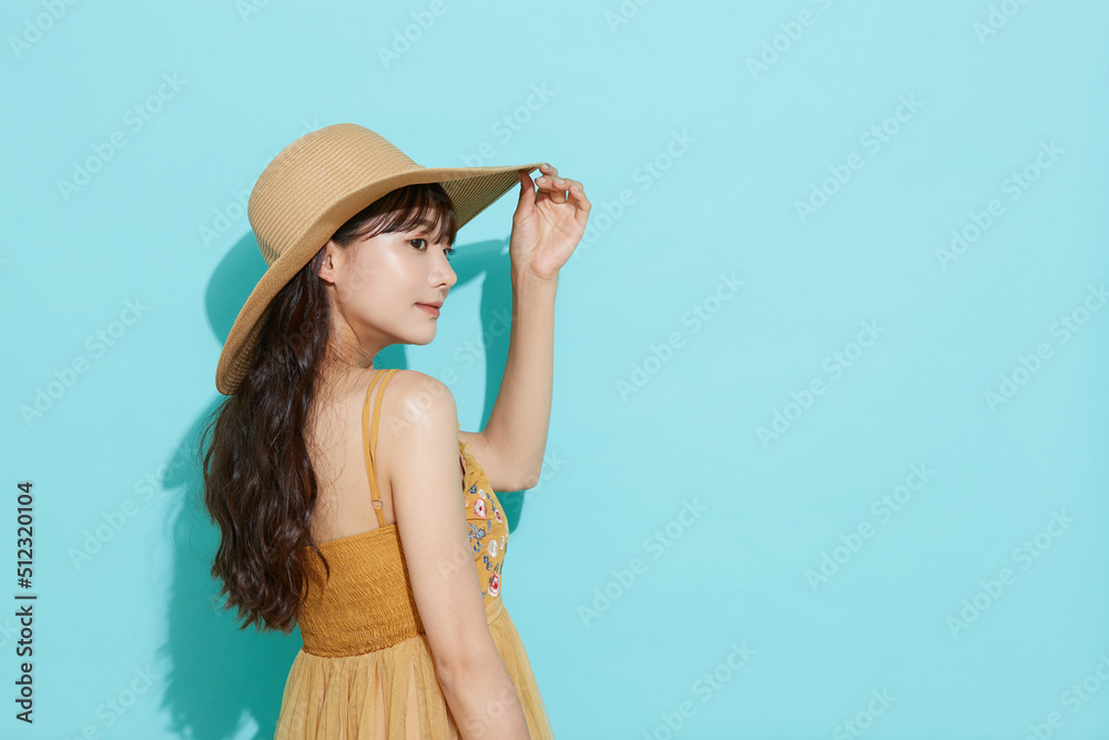 リゾートファッションをした若い女性の青背景のポートレート リゾートファッションをした若い女性の青背景のポートレート
