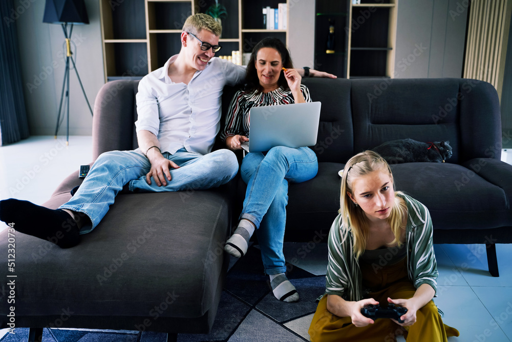 Happy family. Mom and dad shopping online. Children listen to music and play games on weekends in the house. Happy family. Mom and dad shopping online. Children listen to music and play games on weekends in the house.