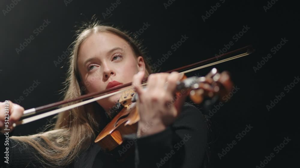 inspired female fiddler is playing classic music concert in philharmonic hall, violinist is playing fiddle