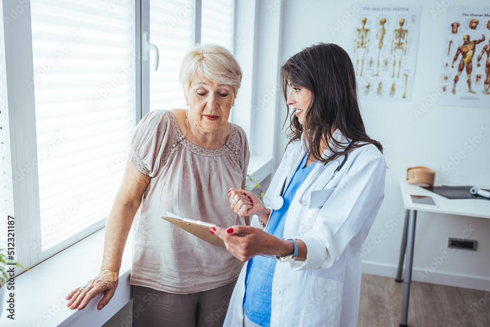 An senior woman speaks with her doctor during a routine check-up in the doctors office. Senior patient listens carefully to the mid adult female doctor. An senior woman speaks with her doctor during a routine check-up in the doctors office. Senior patient listens carefully to the mid adult female doctor.