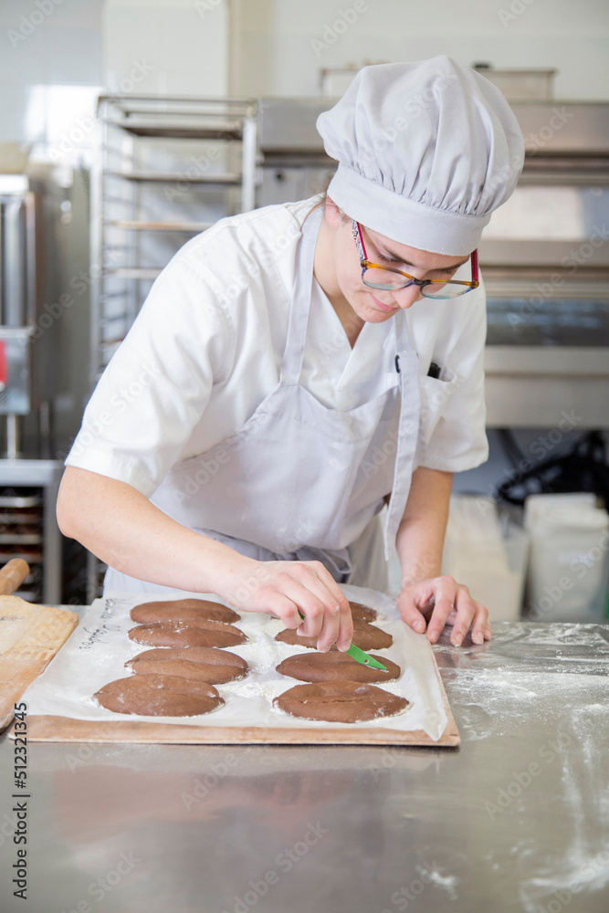 Focused baker preparing cookies in bakery Focused baker preparing cookies in bakery