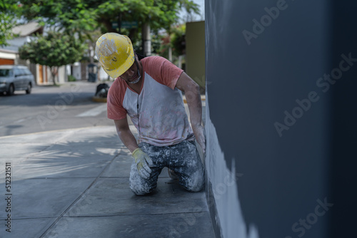 Man plastering wall on street photo