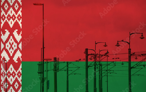 Belarus flag with tram connecting on electric line with blue sky as background, electric railway train and power supply lines, cables connections and metal pole overhead catenary wire