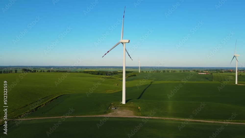 Wind turbines in middle of wheat field generating renewable electric energy and protect environment. Concept of electricity, ecological saving and alternative power source Wind turbines in middle of wheat field generating renewable electric energy and protect environment. Concept of electricity, ecological saving and alternative power source